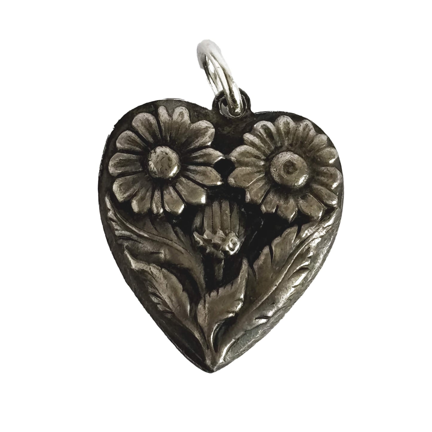 Silver heart-shaped pendant with floral designs on a white background