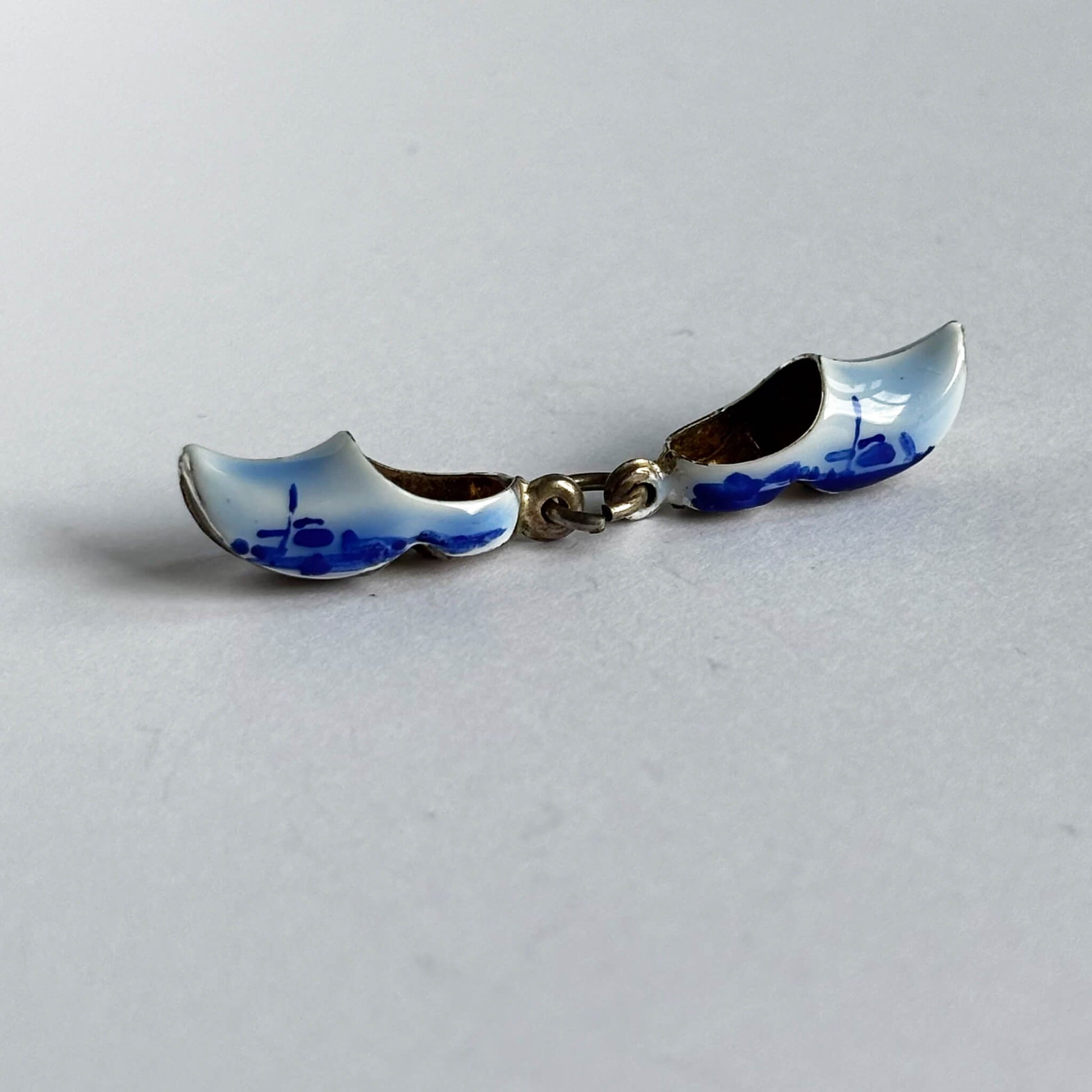 Silver Dutch clogs charm with blue enamel on white background