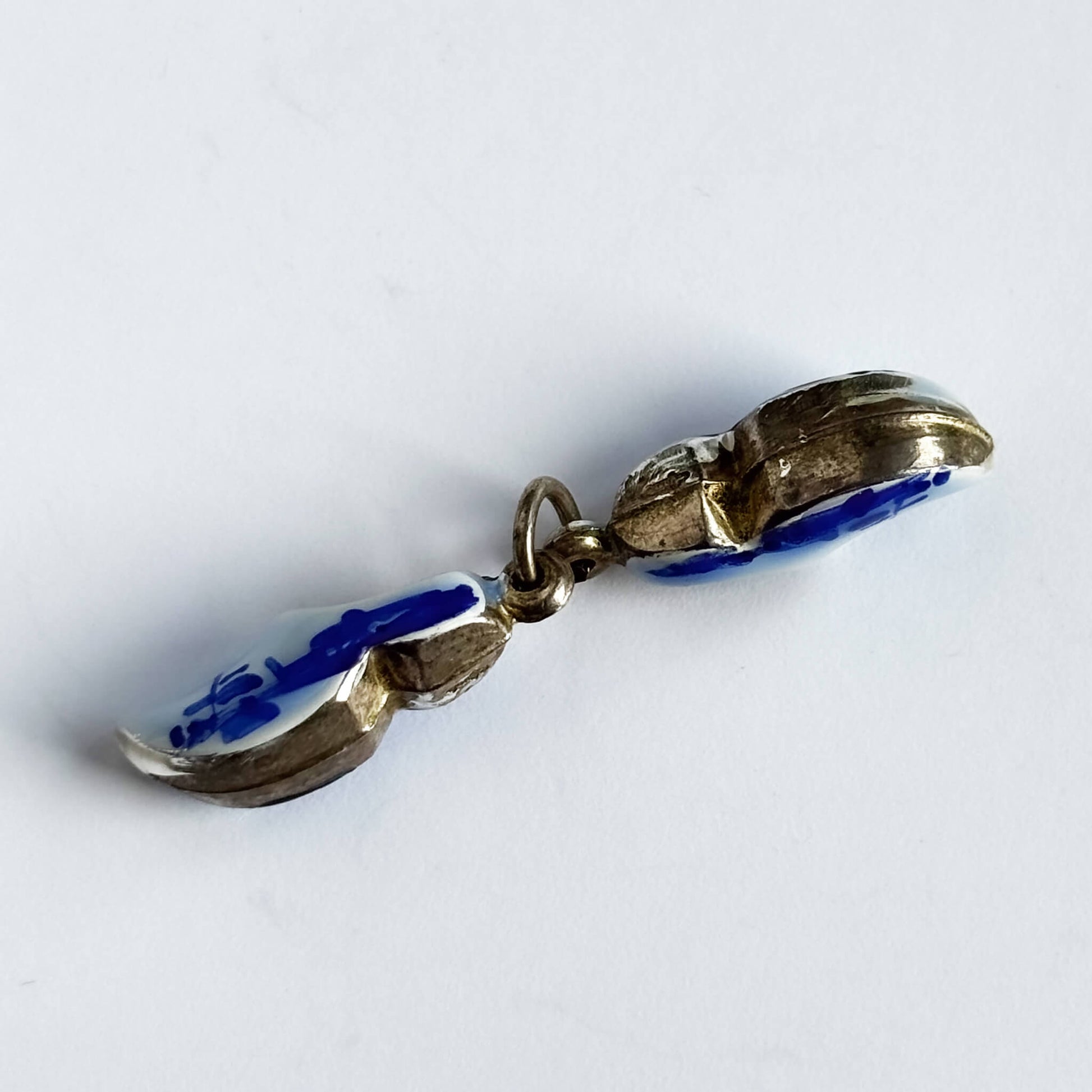 Silver Dutch clogs charm with blue enamel on white background