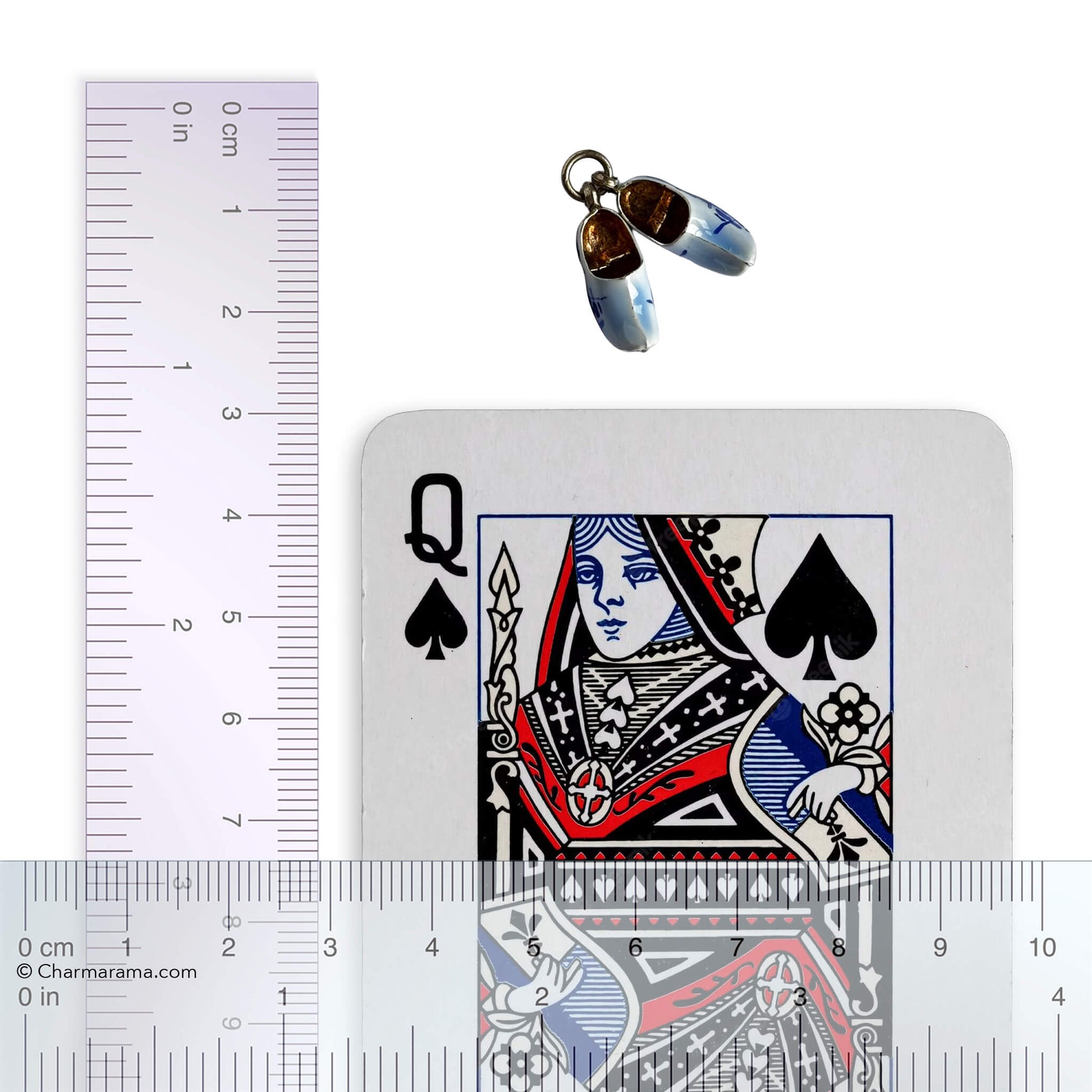 Silver Dutch clogs charm with playing card and ruler on white background