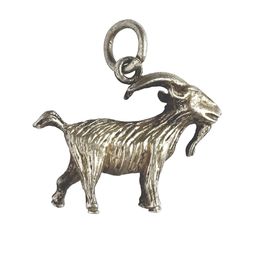 Silver goat charm on a white background