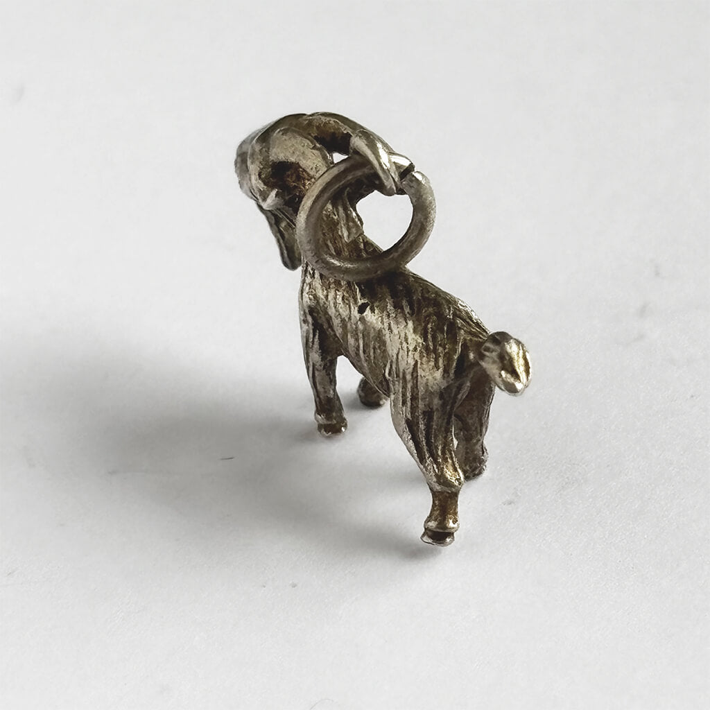 Silver vintage goat charm on a white background