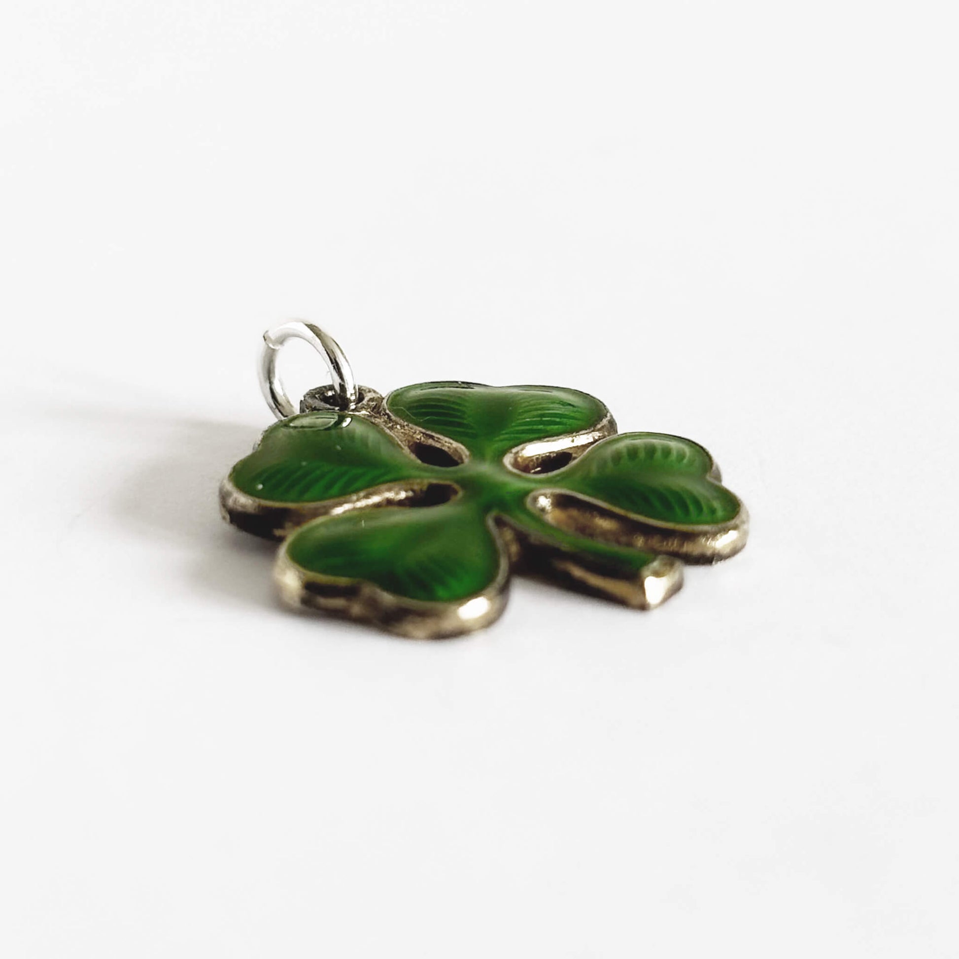 Green four-leaf clover charm on a white background