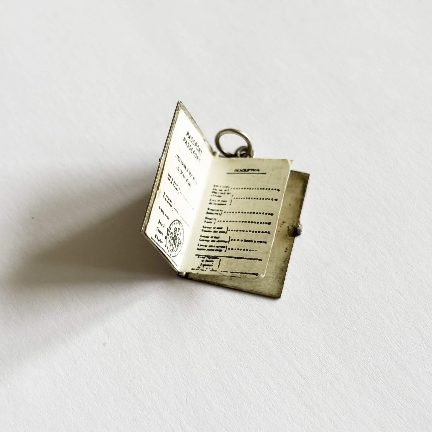 Open passport charm with text on a white background