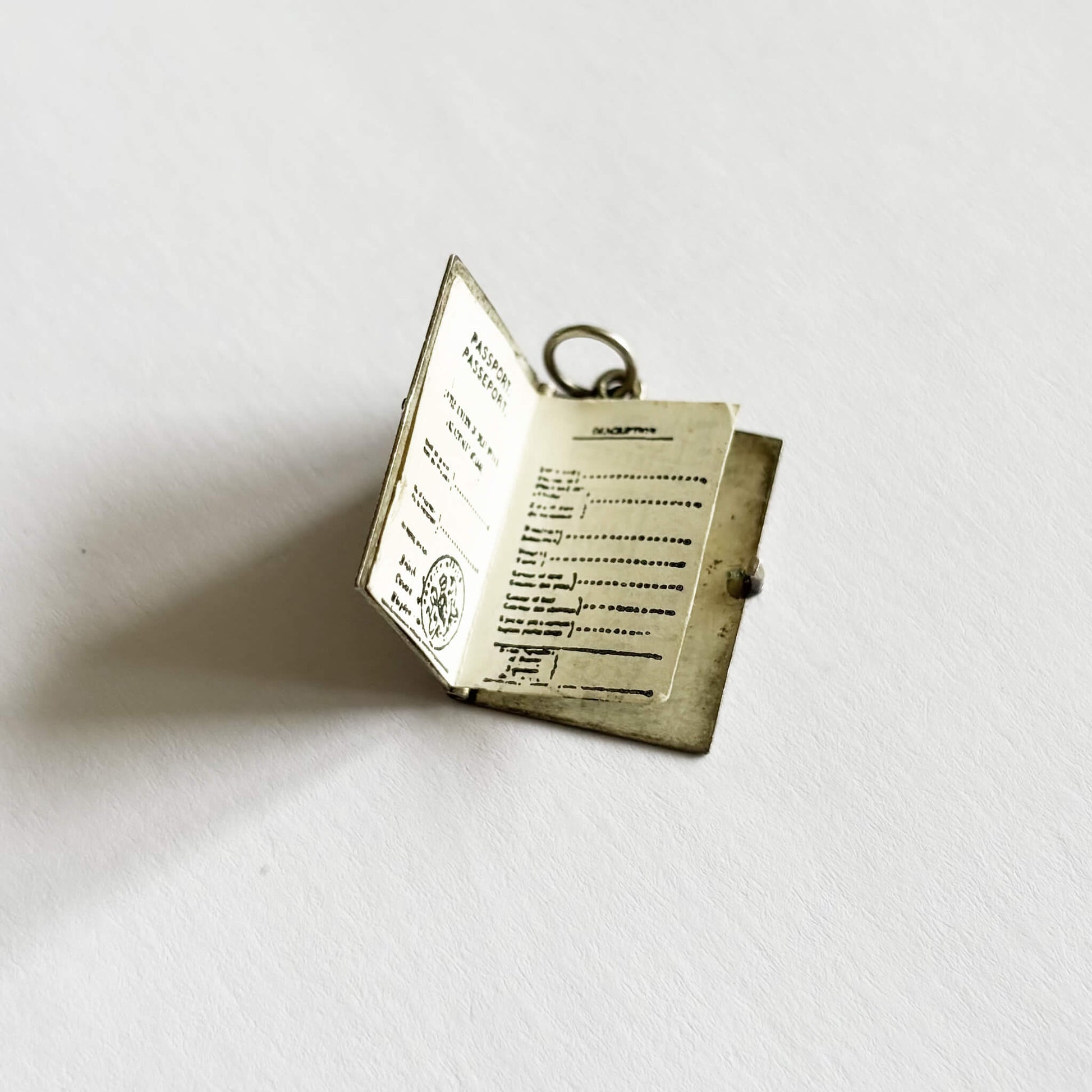 Open passport charm with text on a white background