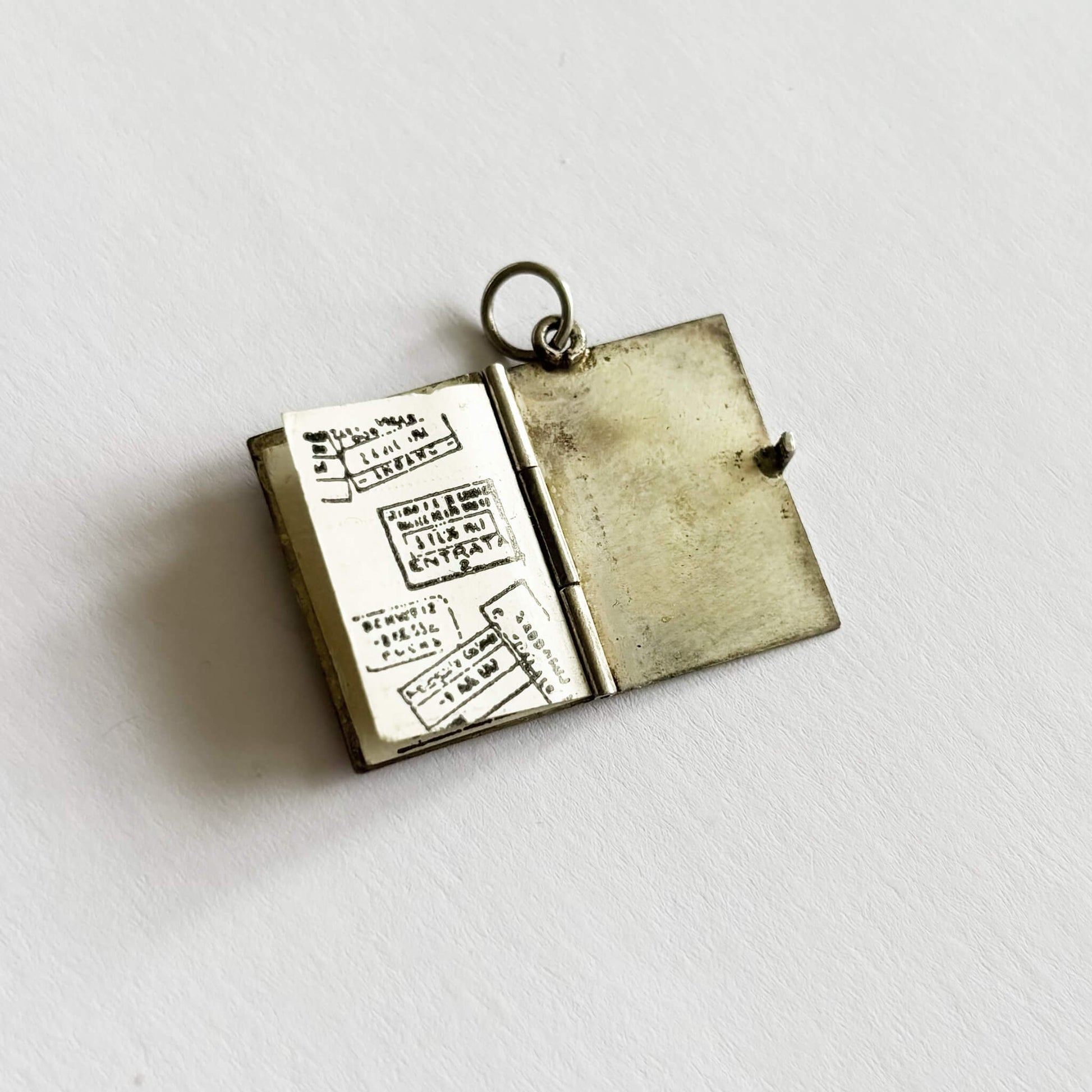 open passport charm with text on a white background