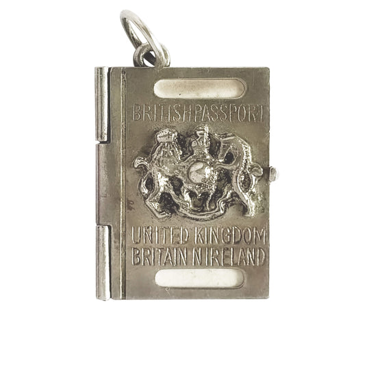 Silver charm resembling a British passport with a coat of arms on a white background