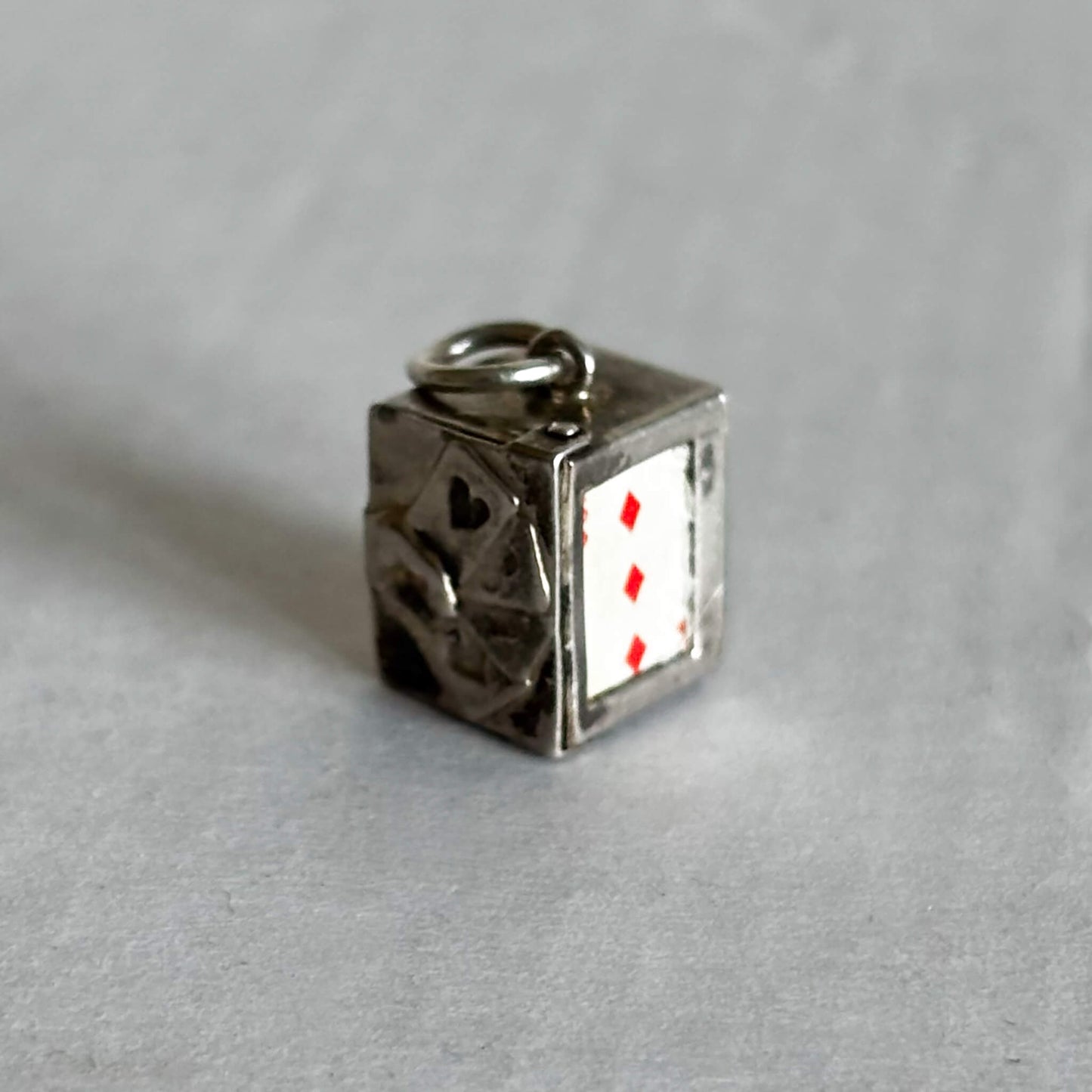 Vintage silver box of playing cards charm on a grey background