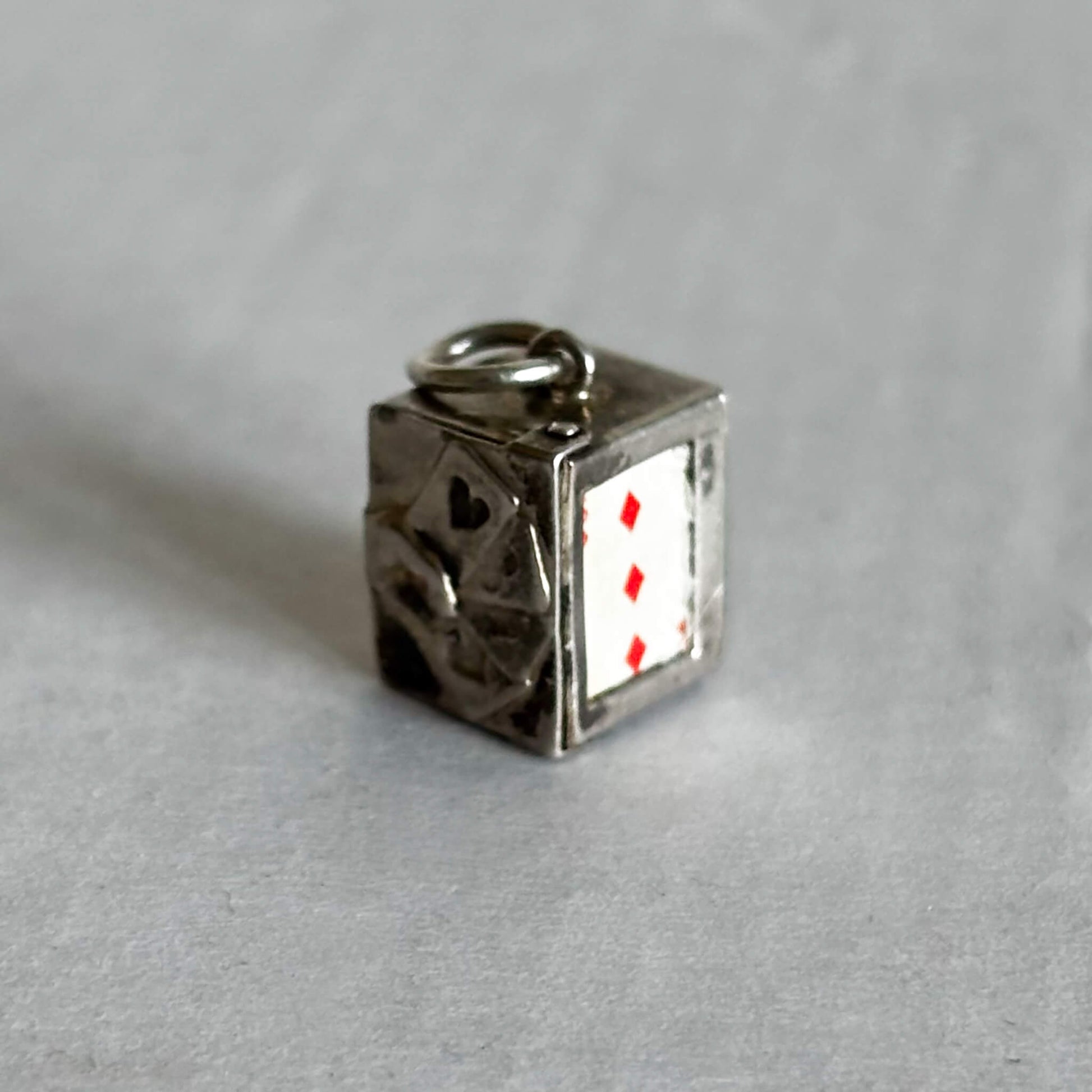 Vintage silver box of playing cards charm on a grey background