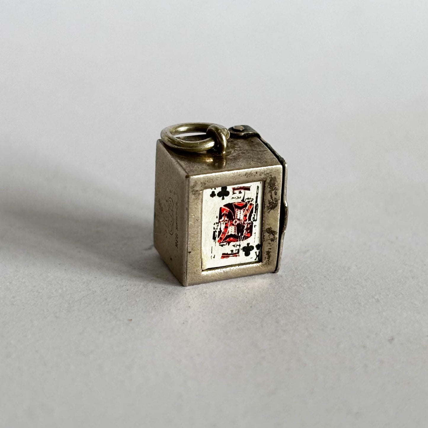 Vintage silver box of playing cards charm on a grey background