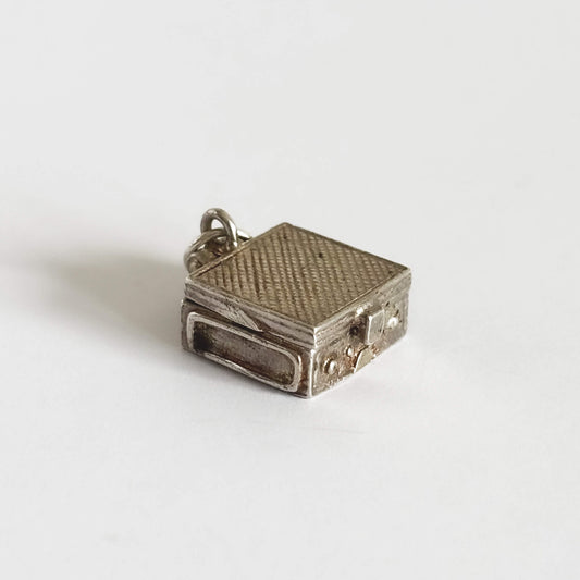 Vintage silver record player case charm  on a white background.