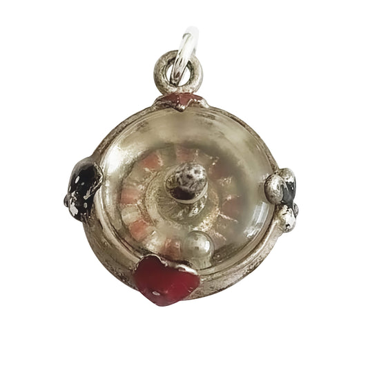 Silver roulette wheel charm pendant with red and black enamel on a white background