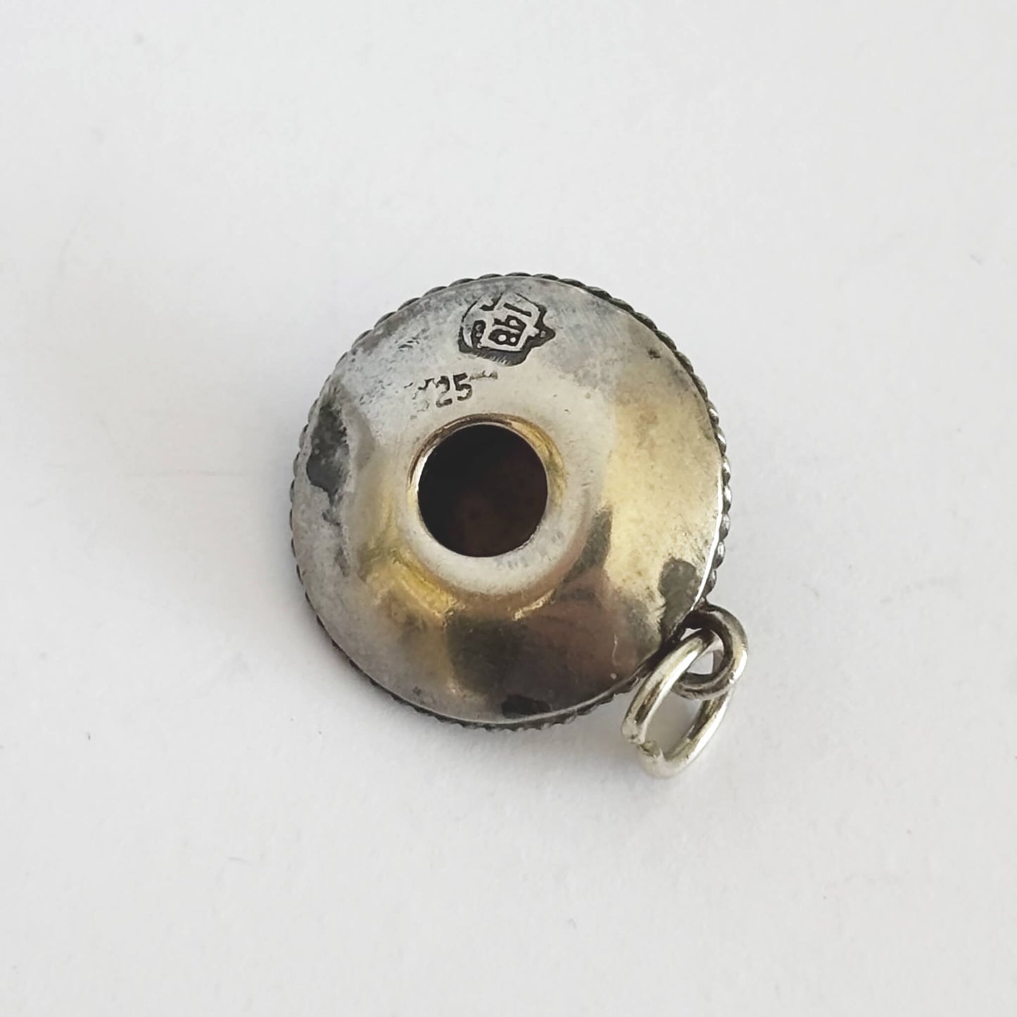 underside of vintage silver sombrero hat charm on a white background