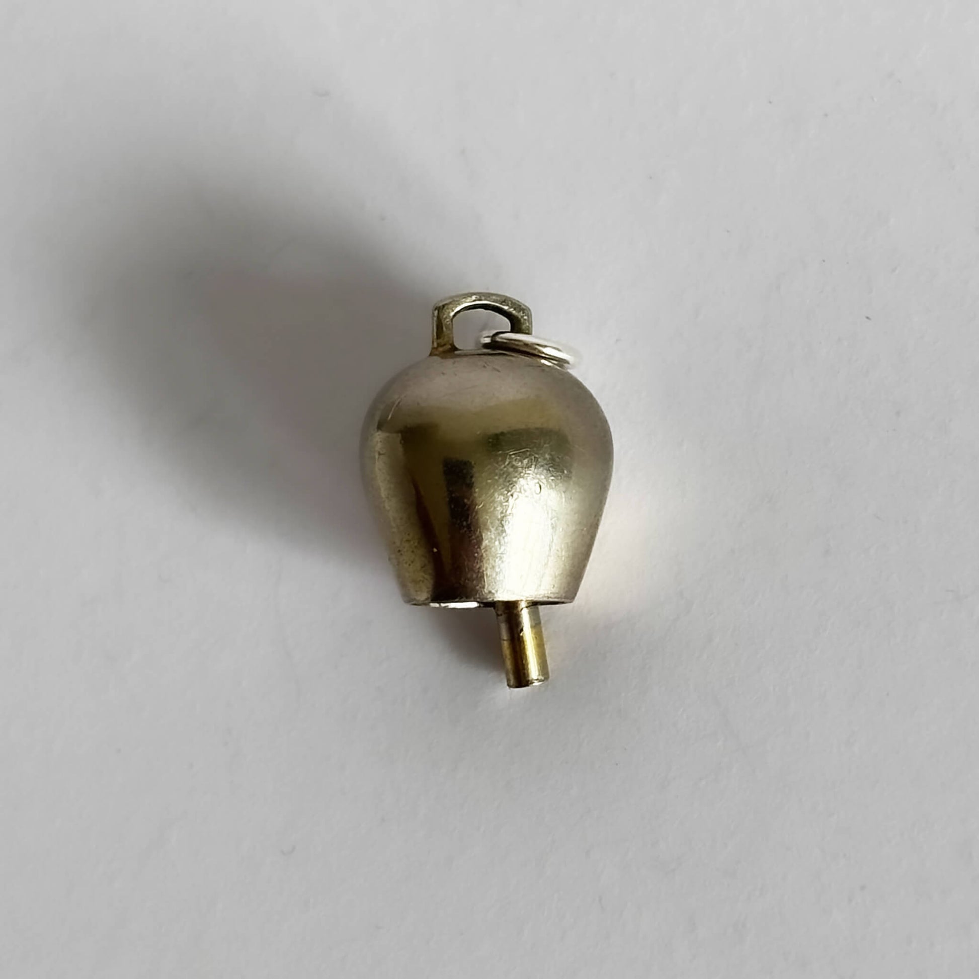 Gold bell charm on a white background