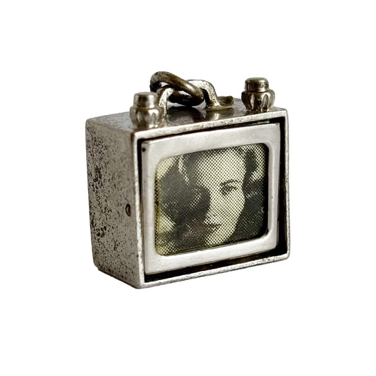 Vintage-style television set charm with a woman's face on the screen against a white background
