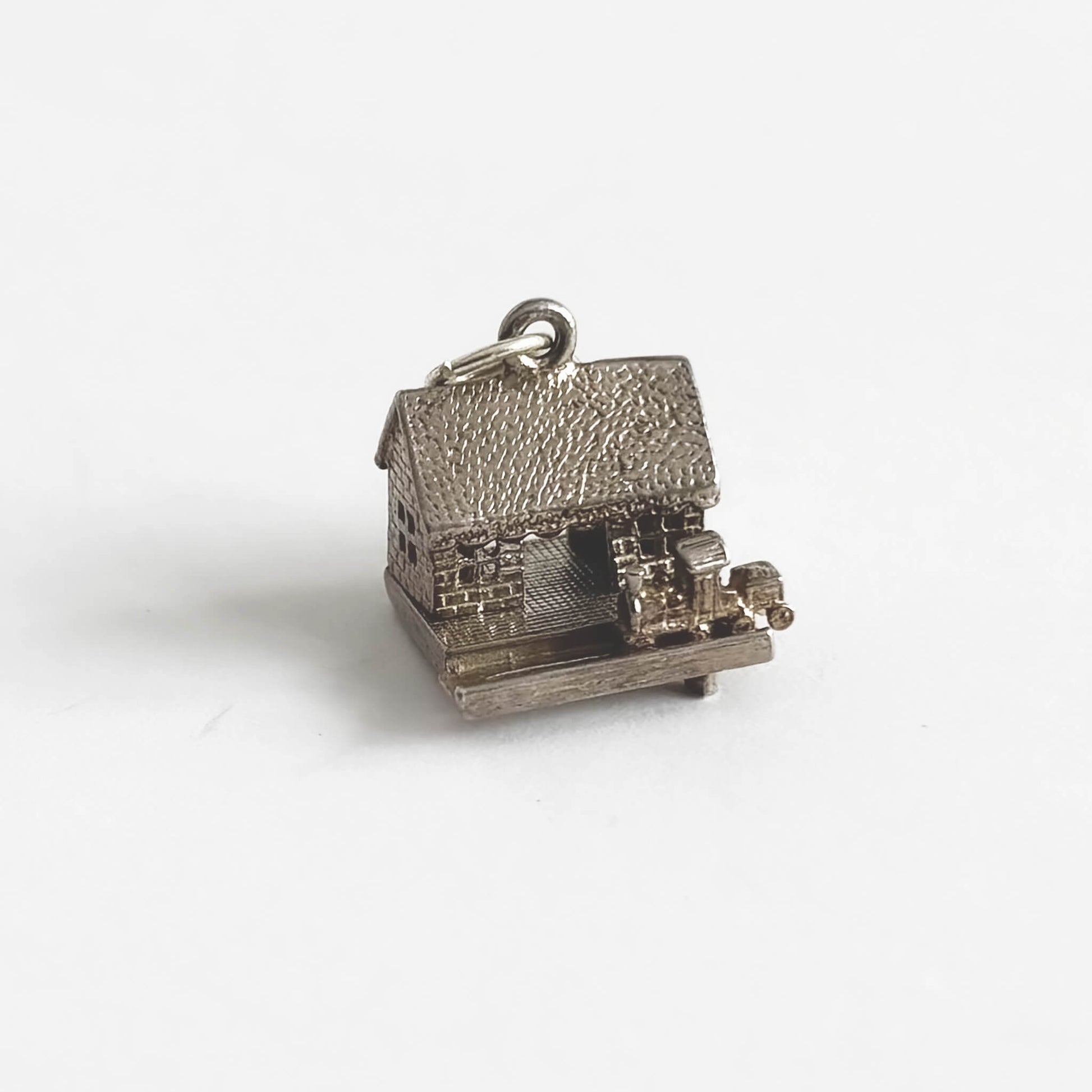 A vintage silver train in station charm on a light grey background