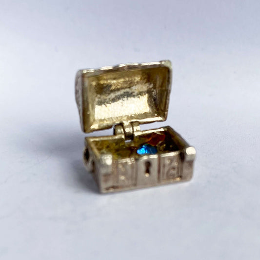 Vintage silver treasure chest charm shown open displaying crystals inside on a white background.