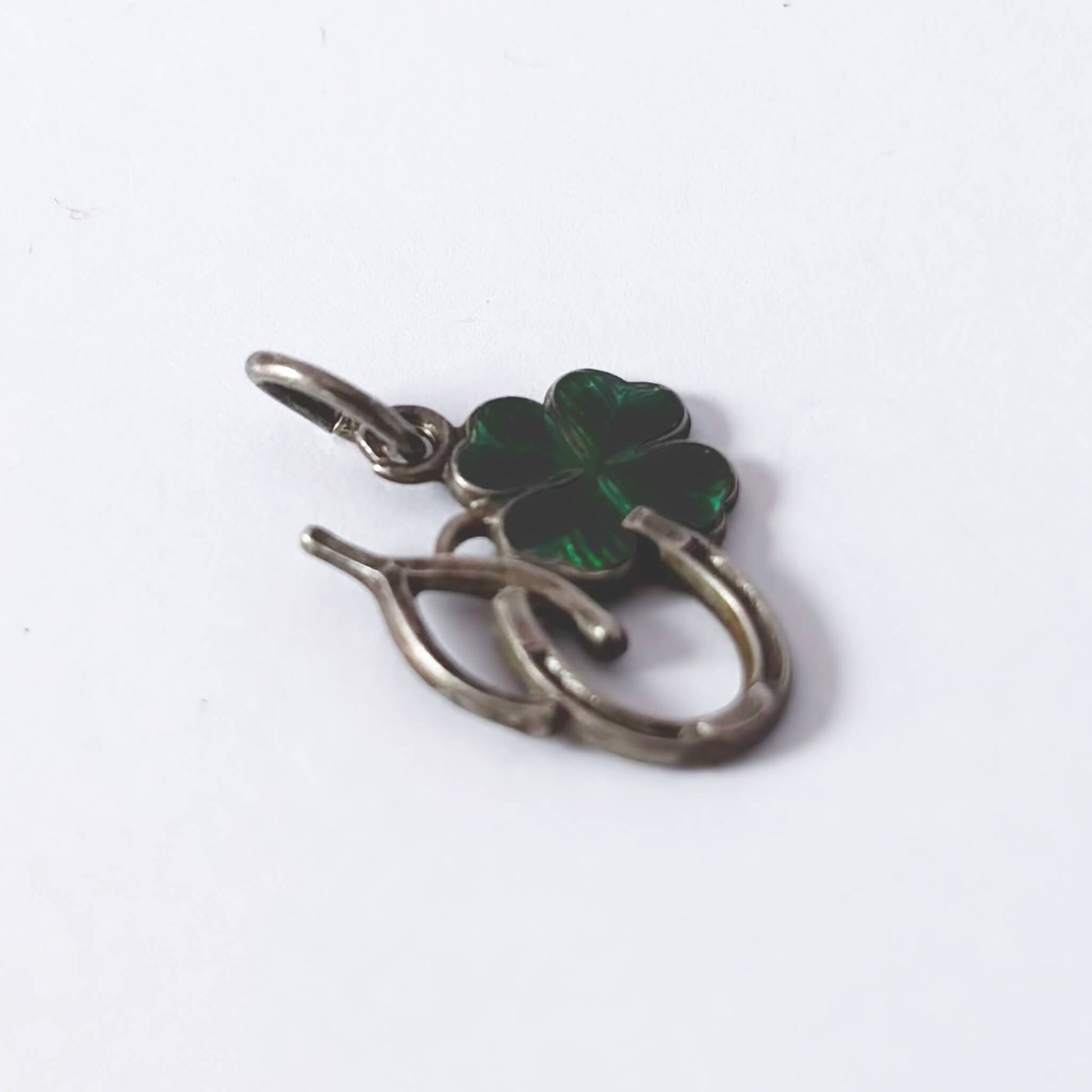 Four-leaf clover pendant with silver border on a white background