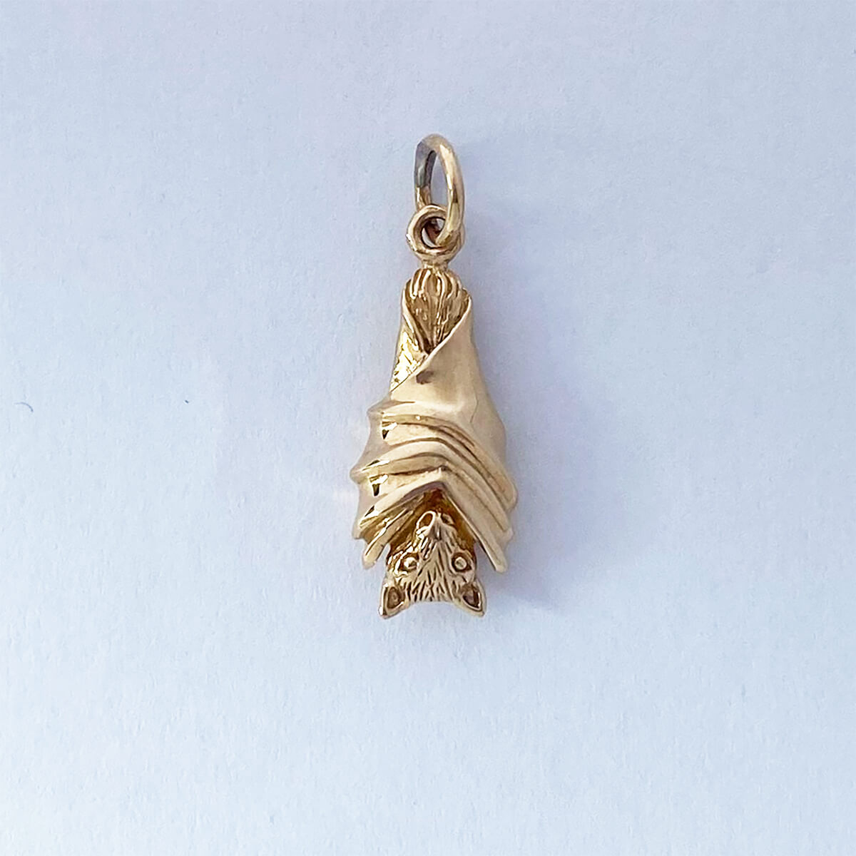 Bat pendant in gold bronze hanging with wings folded