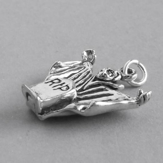 silver dracula charm seen from side on grey background