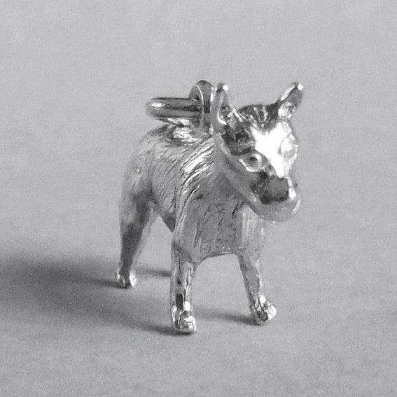 Silver red heeler dog charm seen from side on a grey background.