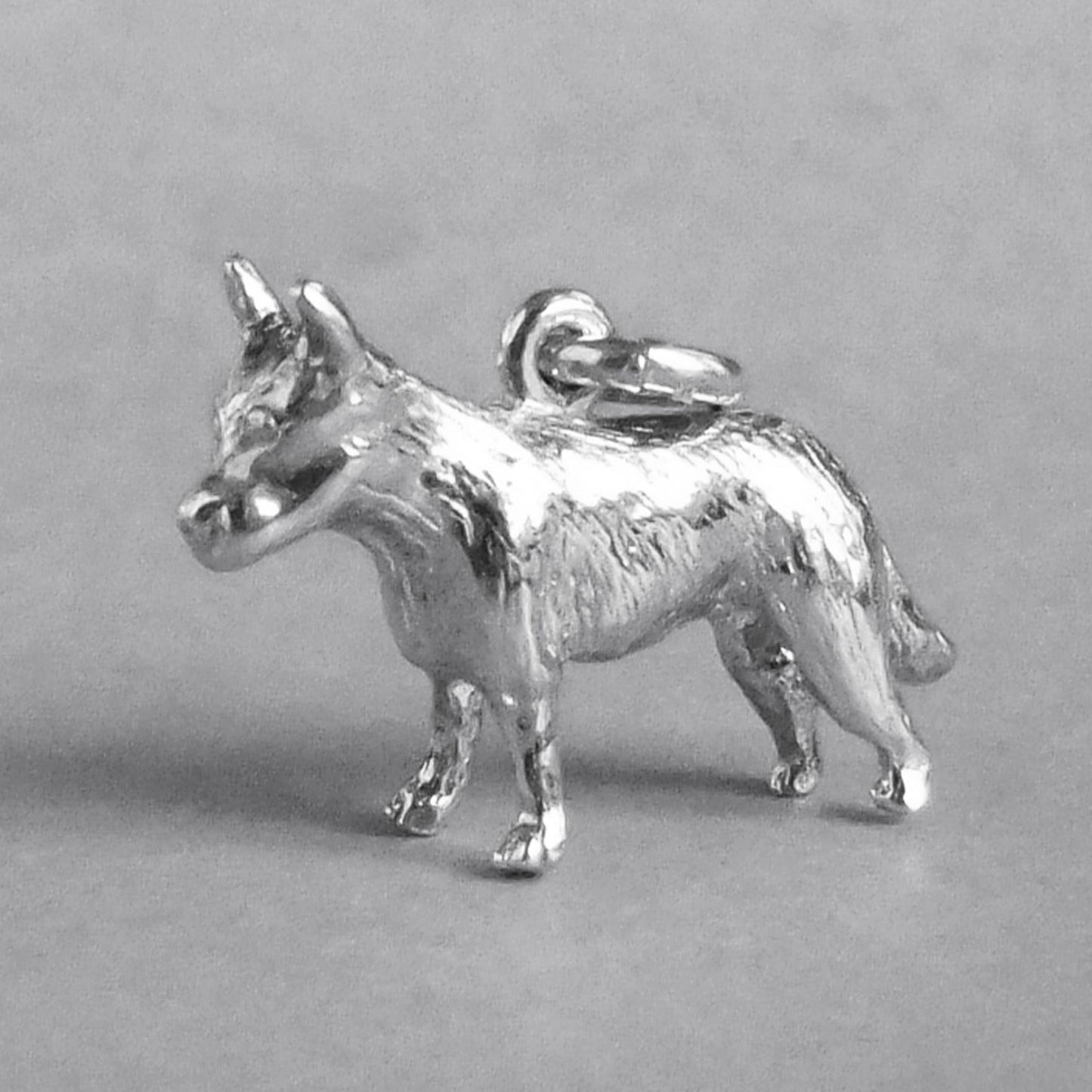 Silver blue heeler cattle dog charm seen from side on a grey background.