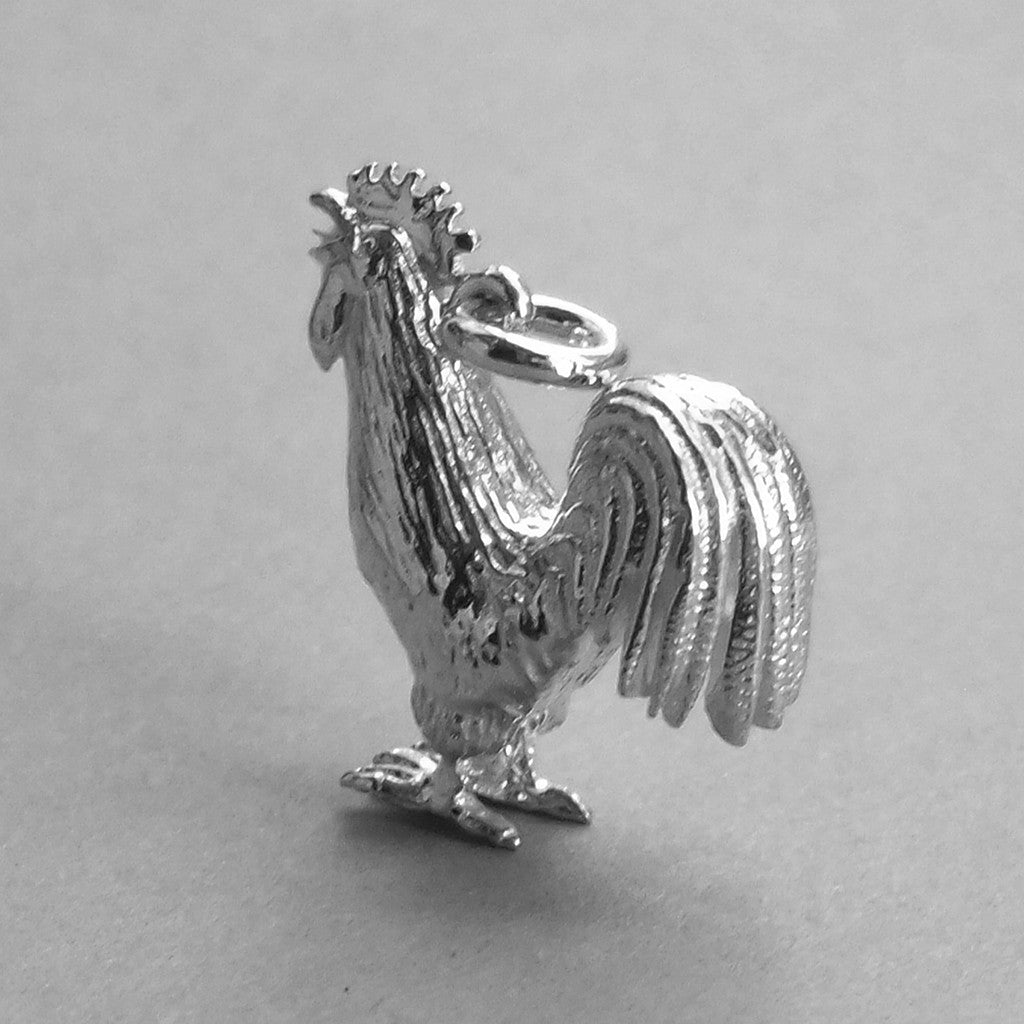 Sterling silver cockerel charm on grey background