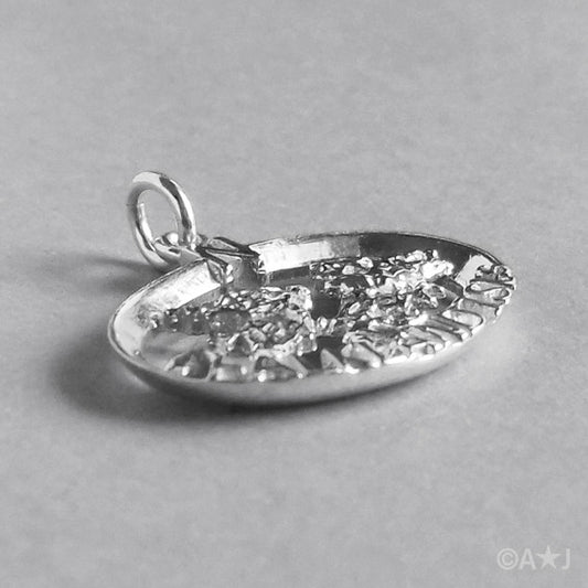 Side view of sterling silver Falkland Islands charm on a grey background