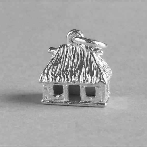 Sterling silver Fijian hut charm on a grey background