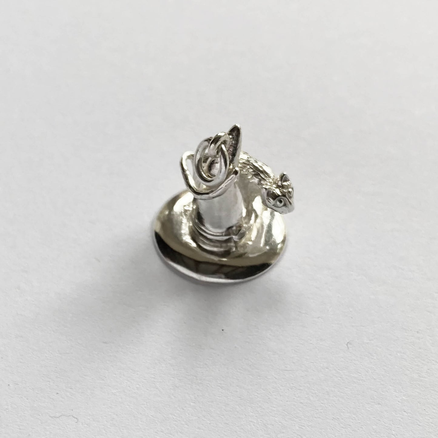silver cat on witch hat charm on a white background