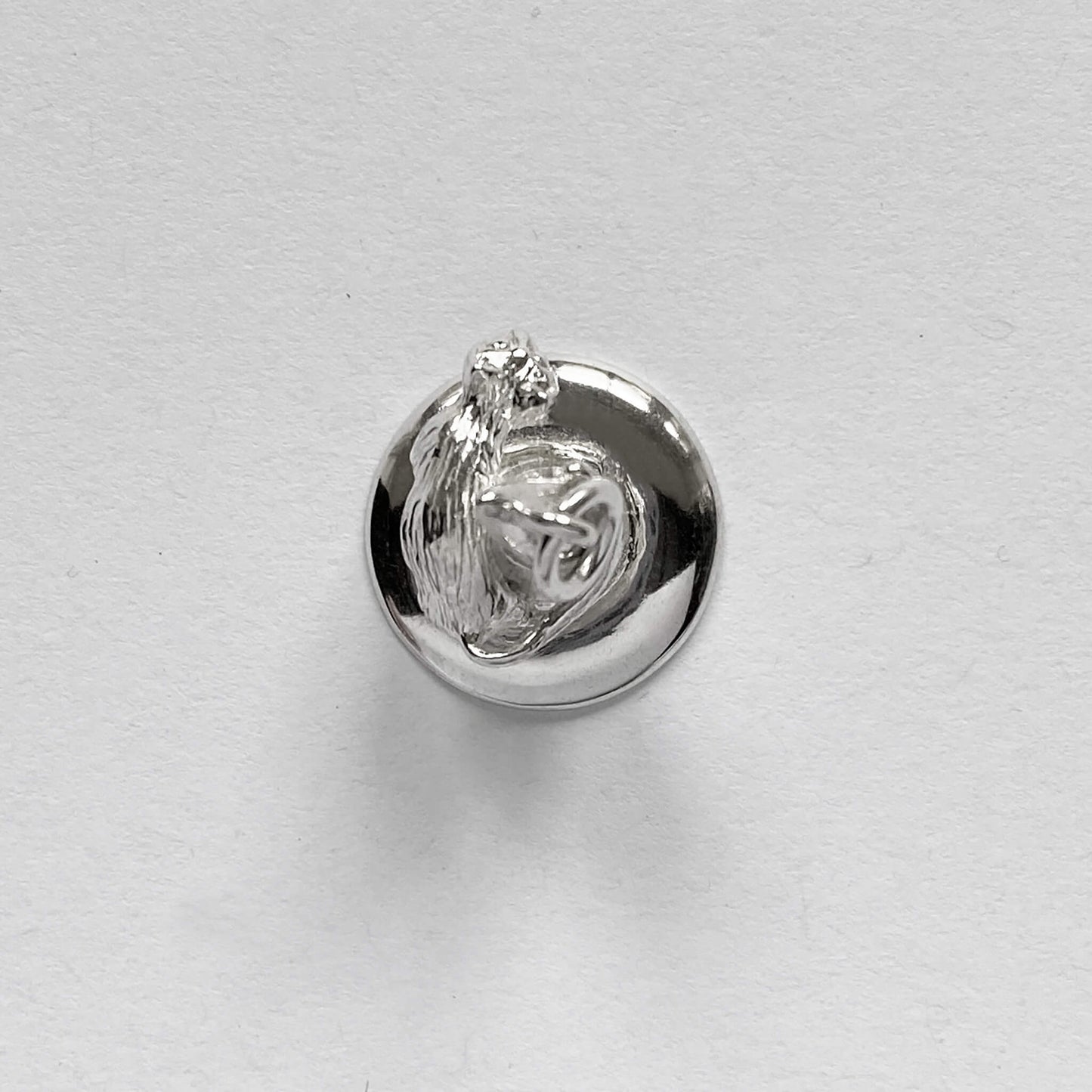 silver cat on witch hat charm on a grey background