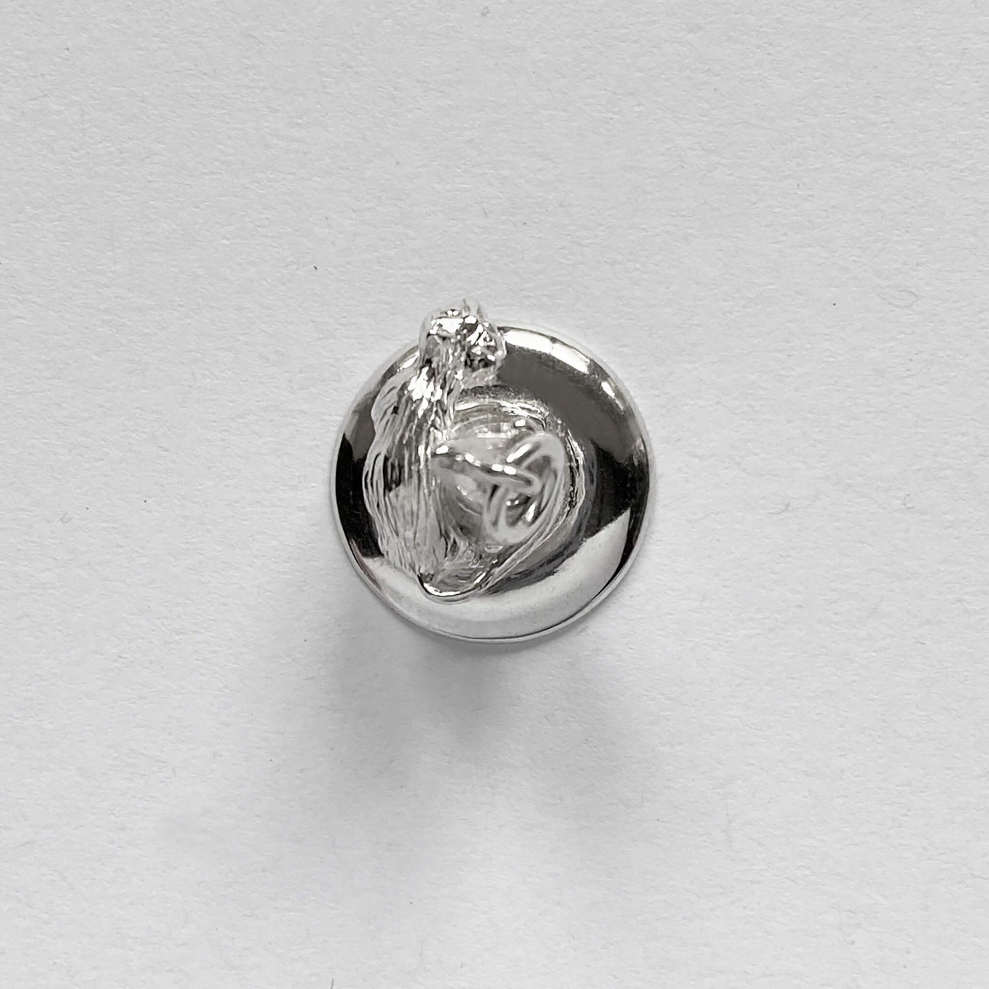 silver cat on witch hat charm on a grey background