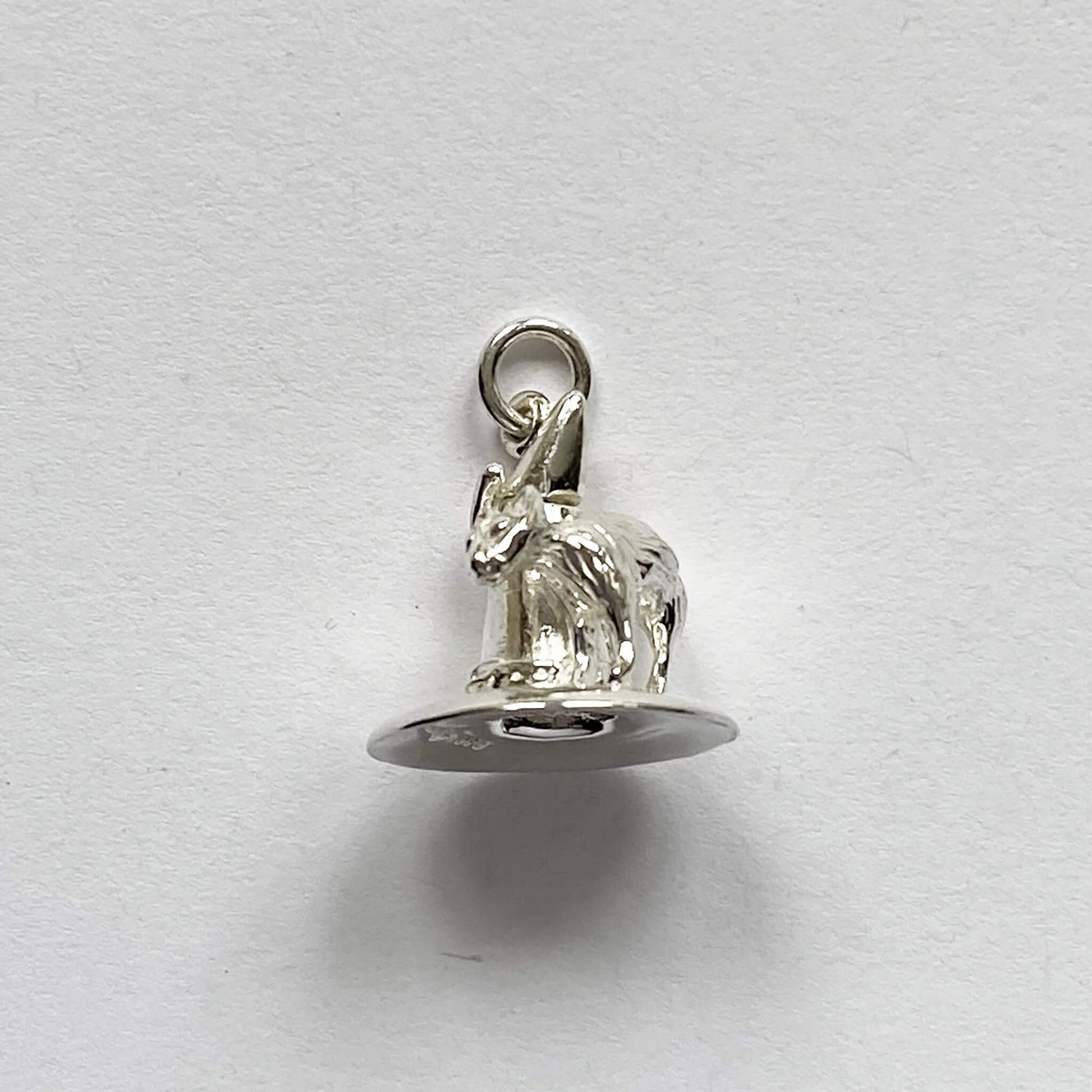 silver cat on witch hat charm on a grey background