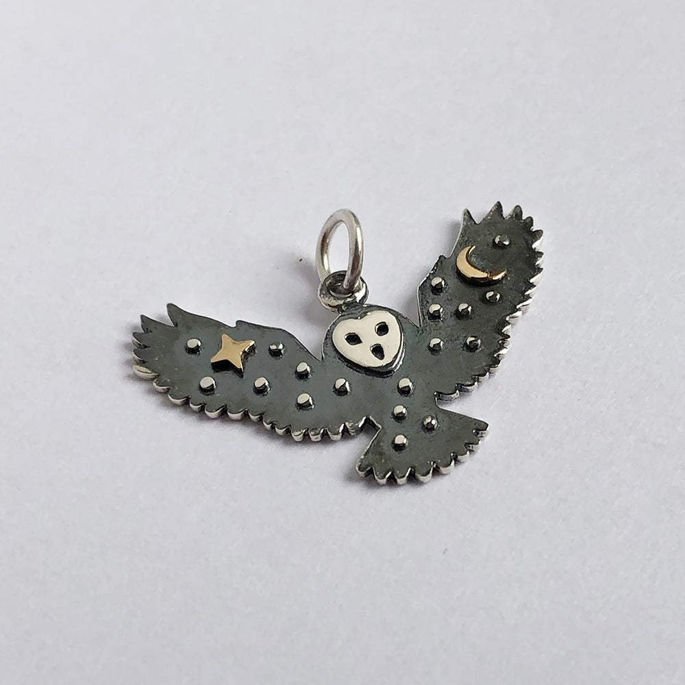 Sterling silver flying owl charm with bronze moon and star decoration on a white background