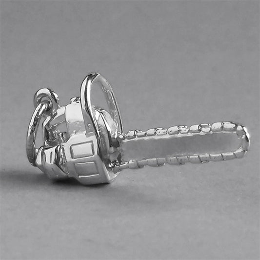 silver chainsaw charm on a grey background