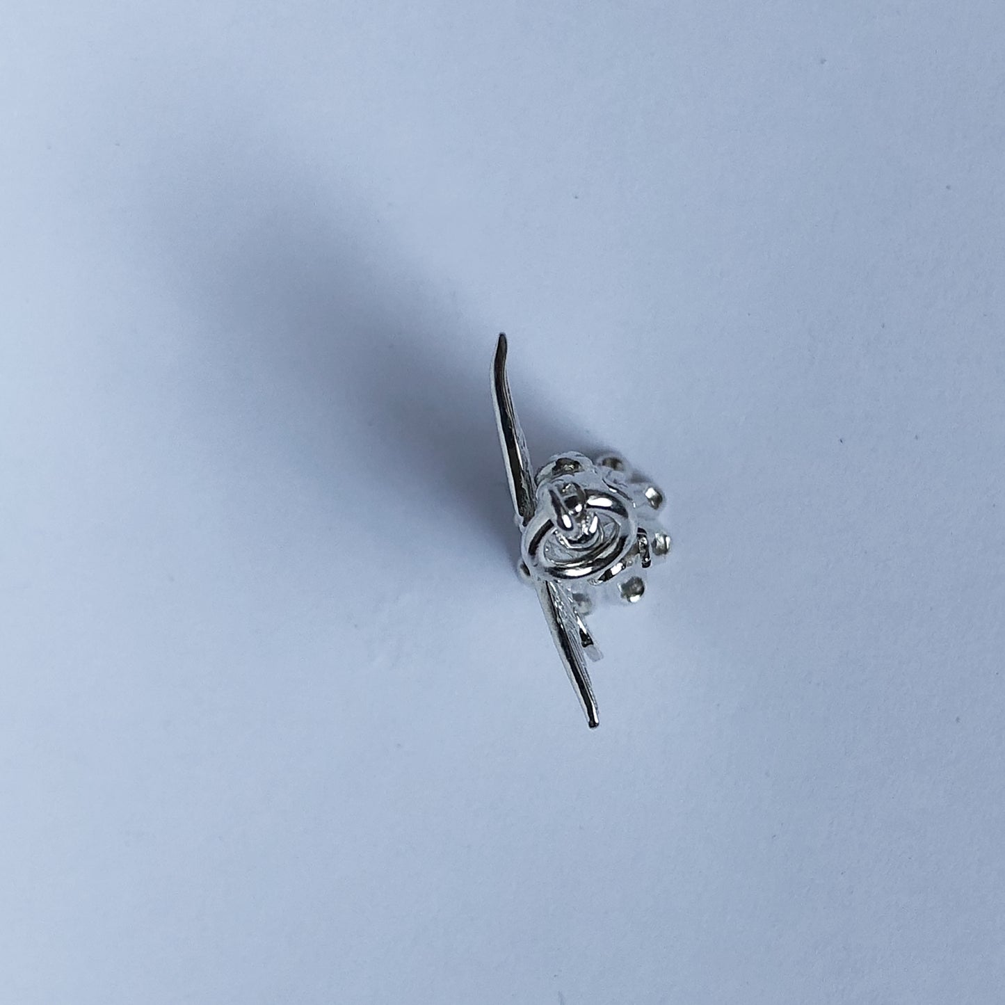 View from above of sterling silver Christmas tree fairy charm on a white background