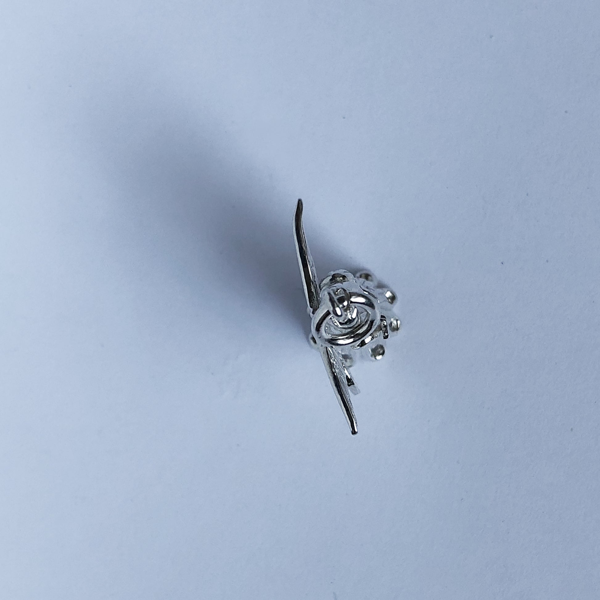 View from above of sterling silver Christmas tree fairy charm on a white background
