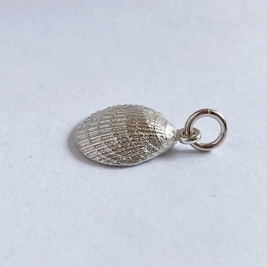 Sterling silver cockle shell charm on grey background