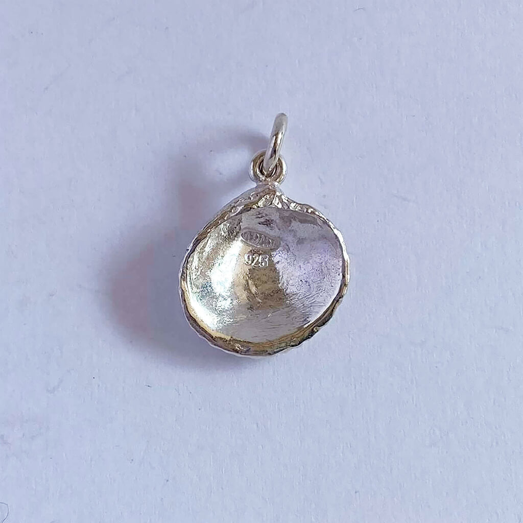 Sterling silver cockle shell charm on grey background