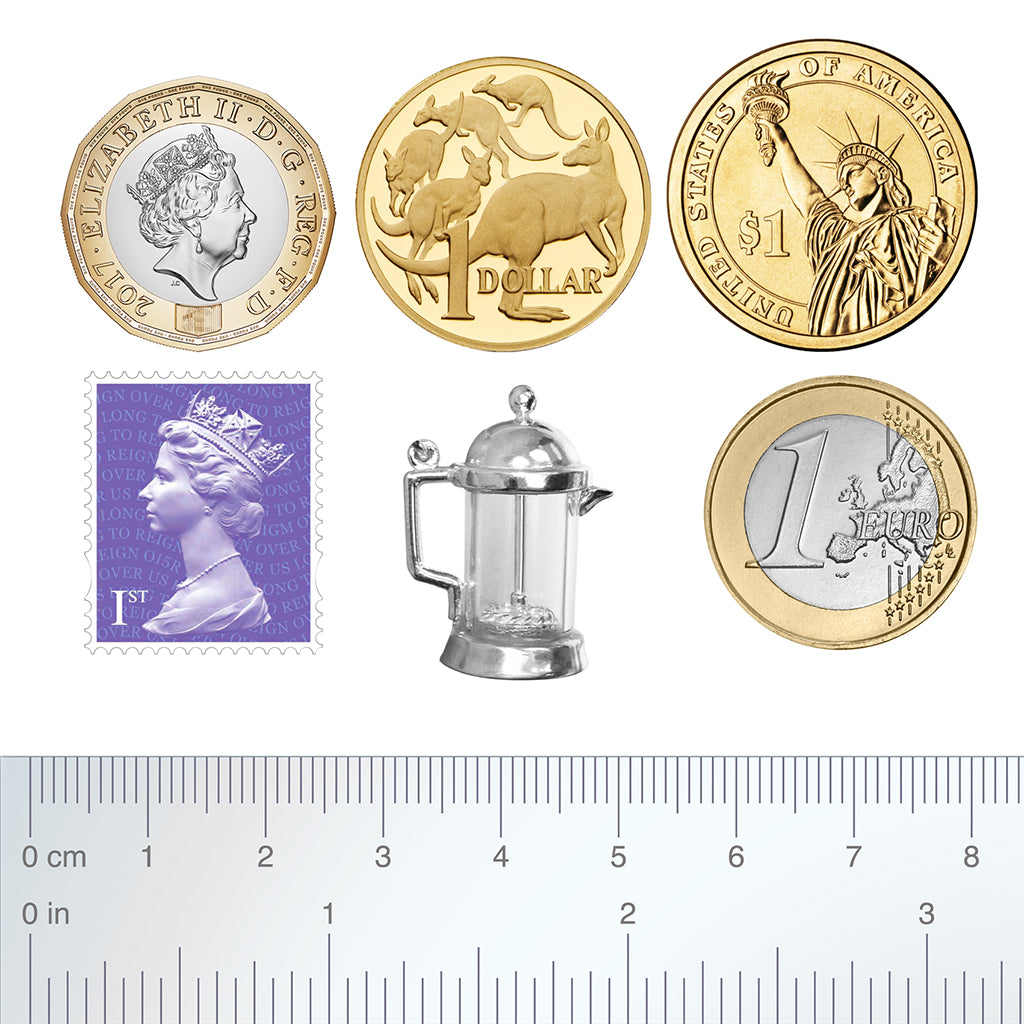 Sterling silver coffee plunger charm with coins stamp and ruler for scale on a white background