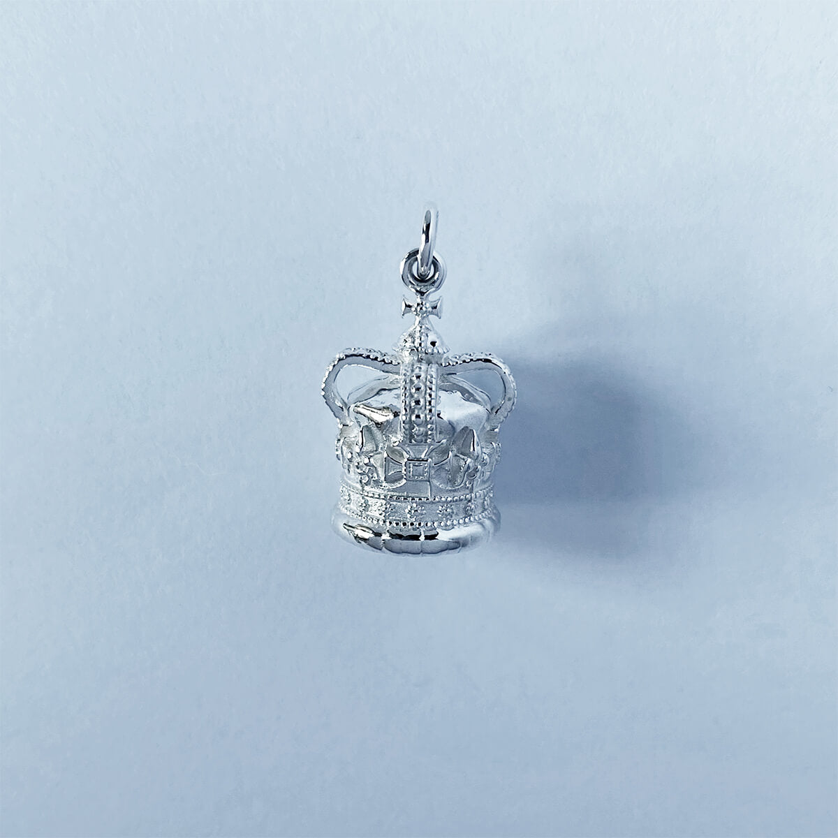 Sterling silver St Edward's crown charm on a grey background