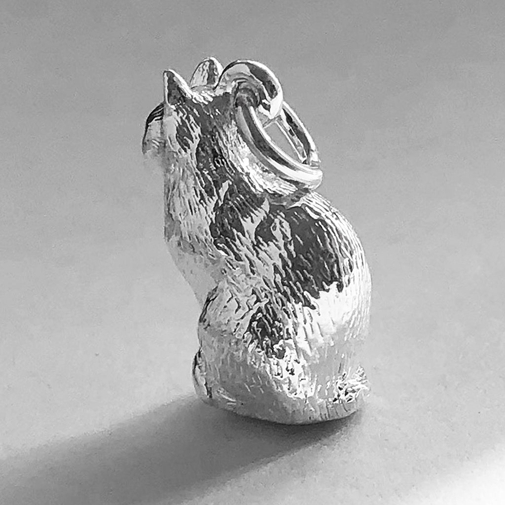 Sterling silver sitting domestic cat charm on a white background