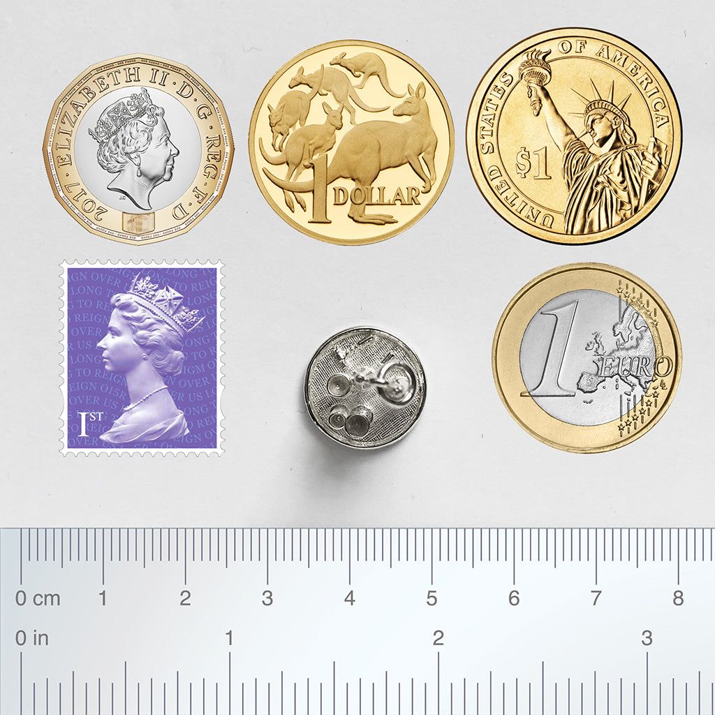 Sterling silver drinks tray charm with coins, postage stamp and ruler for scale on a white background