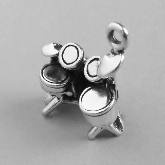 Sterling silver drum kit charm on a grey background