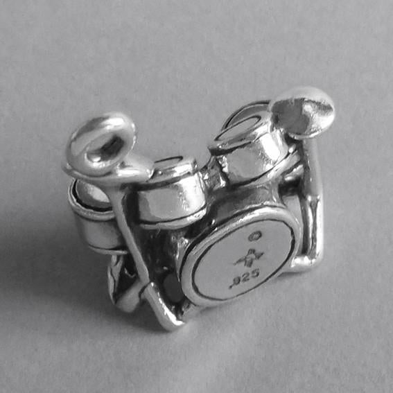 Sterling silver drum set charm on a grey background