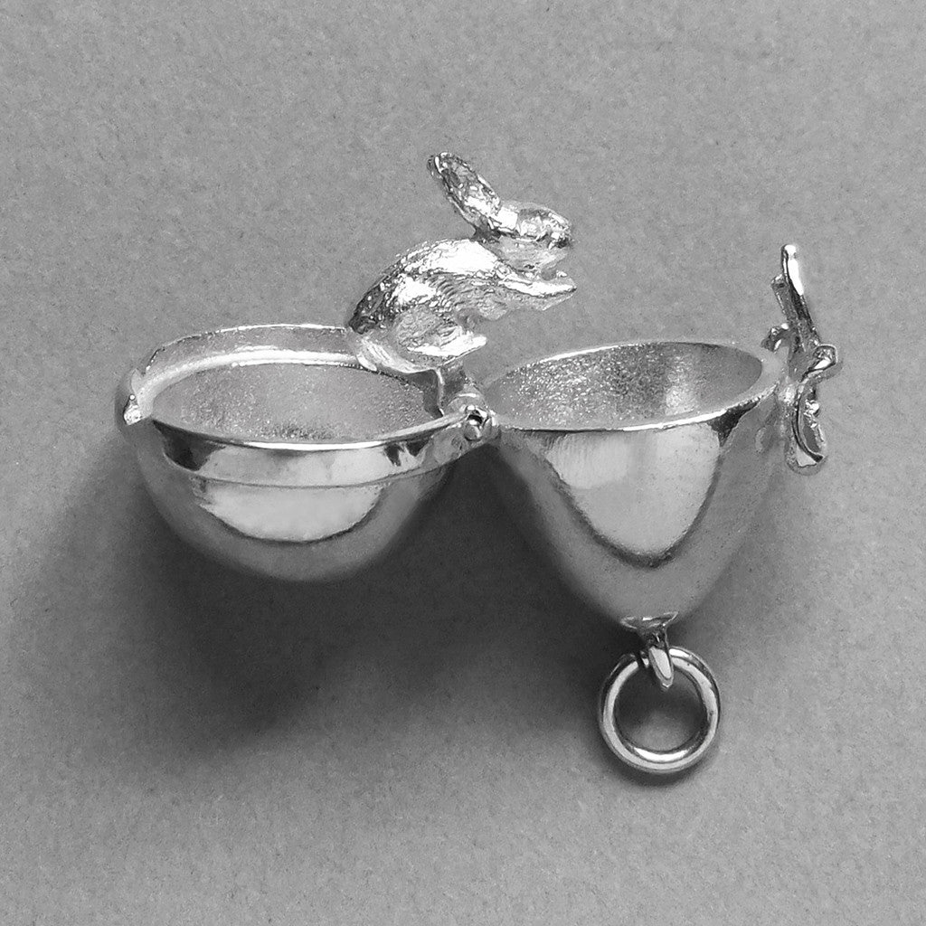 Sterling silver Easter egg charm with bunny rabbit inside on a grey background