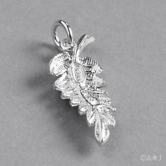 back of a sterling silver fern leaf charm on a white background