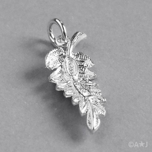 back of a sterling silver fern leaf charm on a white background