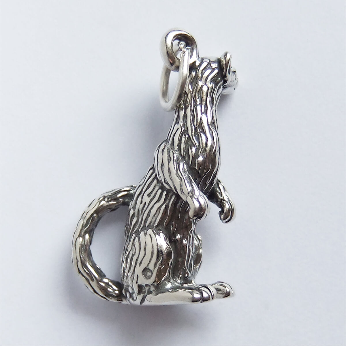 Back of sterling silver ferret charm on a white background