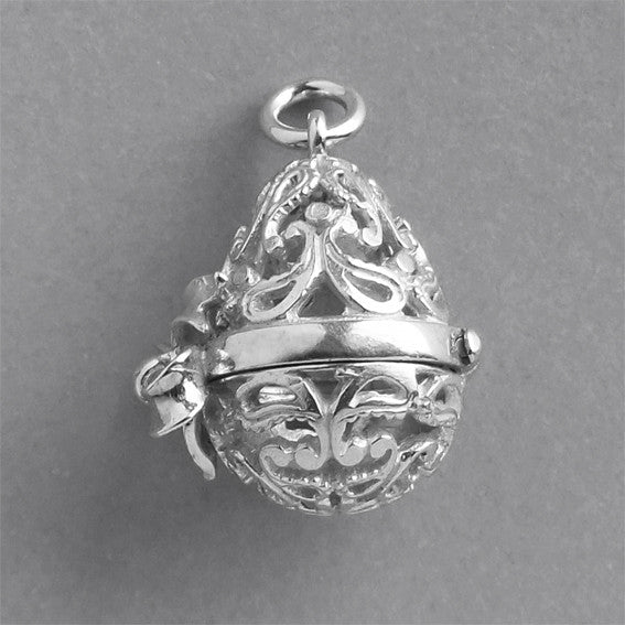Sterling silver filigree egg charm on a grey background